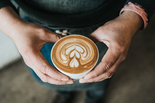 Man holding coffee with latte art